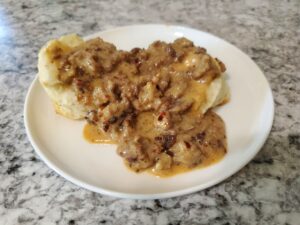 A plate of biscuits smothered with sausage gravy. 